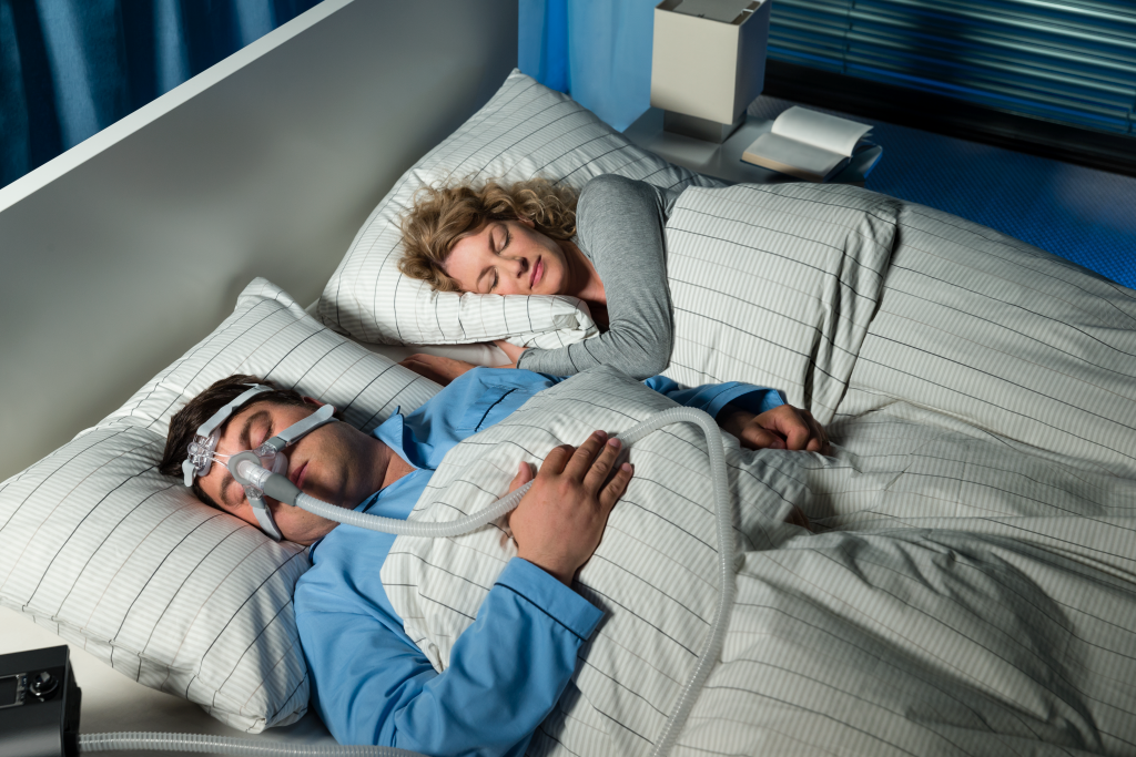 Máquina cpap para la apnea del sueño al lado de una cama